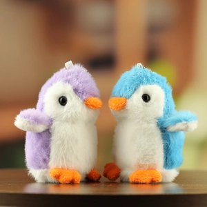 Detail van pluche pinguïn hangers in paars en blauw met zachte textuur en een sleutelhanger