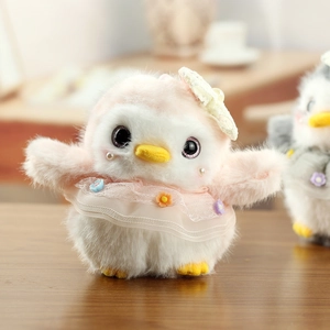 Close-up of cute pink penguin plush doll wearing delicate white lace dress and hat