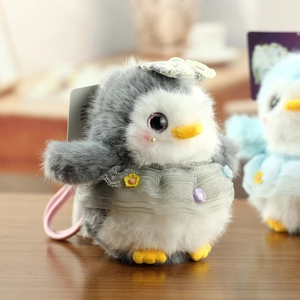 Close-up of cute plush penguin keychain with gray lace dress and colorful flower details