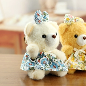 Détail de breloques ours en peluche portant des robes fleuries et des nœuds papillon