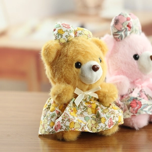 Gros plan d'ours en peluche avec robes à fleurs et bandeaux à nœuds assortis