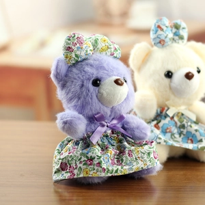 Détail de pendentifs ours en peluche en robes florales avec texture douce et nœuds