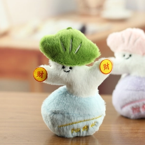 Dettaglio di una dolce bambola di peluche a forma di cavolo con monete fortunate