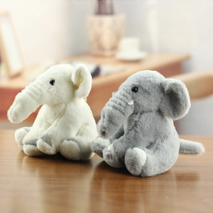 Detailed view of two cute plush elephant dolls in grey and white colors on wood