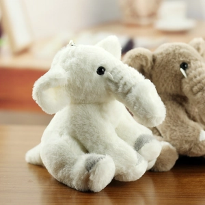 Detail of plush elephant keychains in white and tan colors with soft fluffy texture