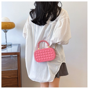 Detailed back view of model wearing pink quilted mini box bag with gold chain strap