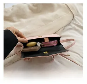 Vue intérieure du petit sac rose effet croco avec téléphone et produits cosmétiques
