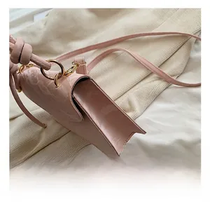 Détail du sac bandoulière en cuir verni rose avec monogramme et mousqueton en métal doré