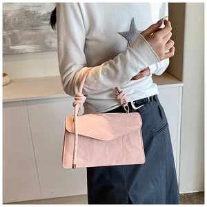Détail du mini sac carré rose clair avec finition brillante plissée et poignée nouée