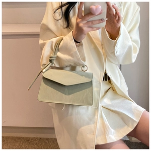 Détail du petit sac vert menthe avec poignée à nœud et rabat style enveloppe
