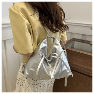 Silver metallic hobo tote bag featuring dual silk ribbon bows and stylish zip detailing