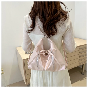 Detail of pink PU leather tote backpack featuring sweet bows and vertical zip pockets