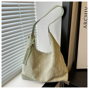 Détail du sac hobo vert menthe avec texture plissée et étiquette de mode