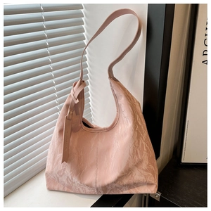 Détail du sac hobo plissé rose clair avec pendentif logo mode et texture brillante