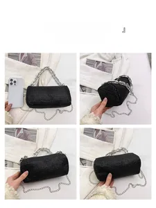 Detailed views of a black rhinestone cylinder handbag with metallic chain and compact size