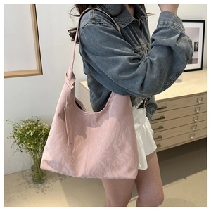 Détail du grand sac cabas rose avec texture froissée et bandoulière nouée au style minimaliste