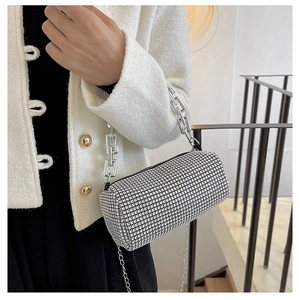 Macro shot of silver rhinestone cylinder bag with thick metal chain and strap detail
