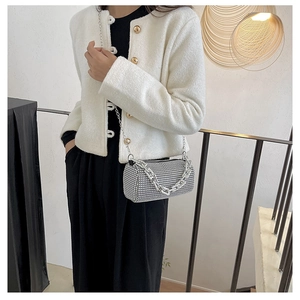 Close-up of sparkling silver rhinestone cylinder bag with metallic chain detail