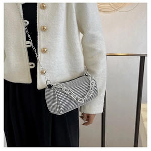 Detail of silver rhinestone cylinder bag with metallic chains and sparkling mesh texture