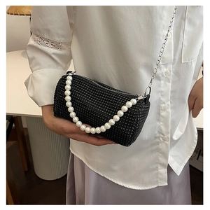 Détail du sac cylindrique noir avec strass, poignée en perles et chaîne en argent