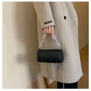 Macro shot of stylish black rhinestone cylindrical bag with chunky silver chain handle