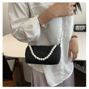 Detail der schwarzen Strass-Zylindertasche mit Perlengriff und silberner Metallkette