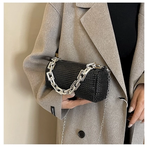 Detail of black cylindrical handbag with shimmering rhinestones and silver chain strap