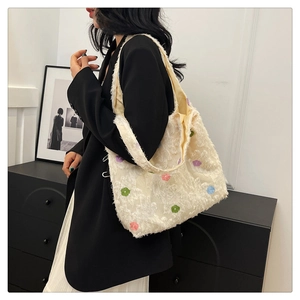 Detailed view of white plush tote bag featuring colorful 3D floral embroidery textures