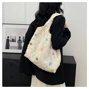 Detail of white tote bag with colorful floral embroidery and soft textured fabric