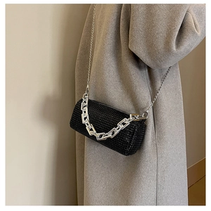 Detail of black rhinestone bucket bag with silver chunky chain handle and shoulder strap