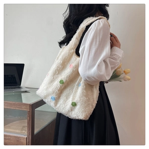 Close-up of white plush shoulder bag featuring colorful 3D flower texture detail