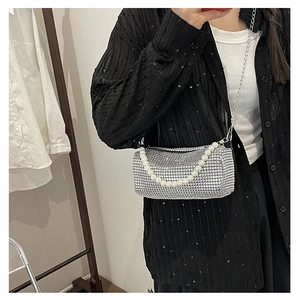 Nahaufnahme der silbernen Strass-Zylindertasche mit Perlenobergriff und Metallkette