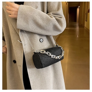Close-up of black cylinder bag with rhinestones and chunky silver chain detail