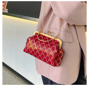 Details der roten Vintage-Umhängetasche mit Goldschuppenmuster und Kettenriemen