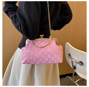 Detail of pink fish-scale sequin texture and golden clasp on a stylish handbag