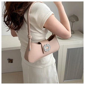 Detailed close-up of light pink baguette bag featuring a luxury square rhinestone buckle