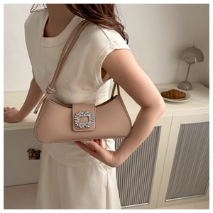 Détail du sac baguette en cuir rose avec boucle carrée en strass et fine bandoulière