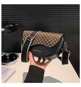 Detail of saddle bag featuring retro floral print flap and stylish wide fabric strap