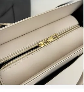 Détail d'une fermeture éclair en métal doré lisse sur un sac cabas crème mat