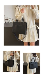 Détail du sac cabas noir avec une large bandoulière à motifs géométriques en cuir synthétique
