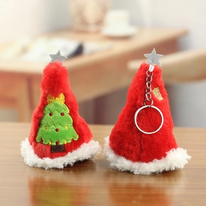 Detail of plush Christmas tree ornaments featuring red cone hats and silver star toppers