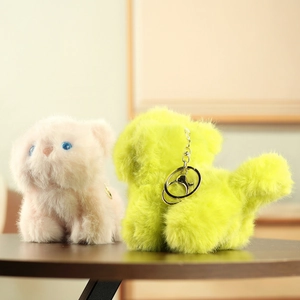 Detail of pink and green plush cat pendants with soft fur texture and metal keychain