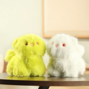 Close-up of soft green and white plush kitten charms with fluffy fur and cute facial details