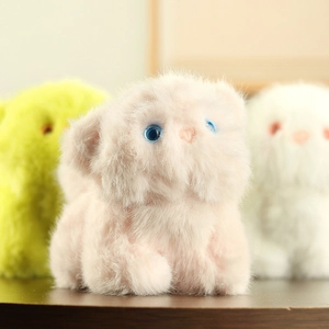 Detailed close-up of fluffy plush cat charms in soft pink, yellow, and white colors