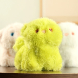 Close-up of cute neon green plush cat keychain with fluffy fur and orange plastic eyes