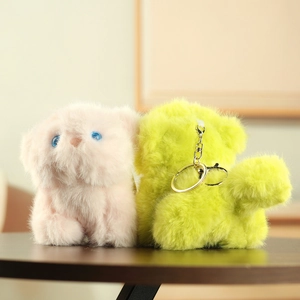 Close-up of soft fluffy cat plush keychains in pink and green with golden metal rings