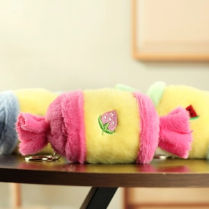 Close-up of candy plush keychain with strawberry embroidery and soft fuzzy texture