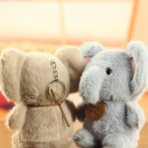 Detailed close-up of fluffy elephant plush pendants in khaki and grey colors