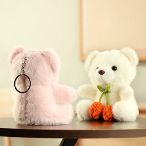 Detail of cute plush bear charms in pink and white with soft fur and metal keychain