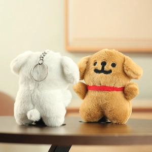 Detail of plush dog keychains in white and brown with silver metal rings and red scarf